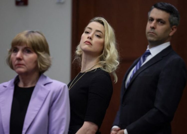 Amber Heard dan pengacara Elaine Bredehoft serta Benjamin Rottenborn mentap juri sebelum mereka mengumumkan juri percaya Heard mencemarkan nama baik mantan suami Johnny Depp dalam kasus defamasi di Fairfax County Circuit Courthouse, Fairfax, Virginia, AS, 1 Juni 2022