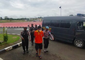 Briptu HSB digiring polisi dengan mengenakan baju tahanan (Foto:Rizky/CAKRANEWS)