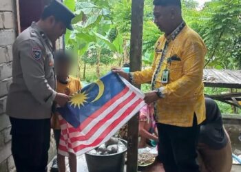 Bhabinkamtibmas dan pihak Kelurahan Karang Anyar saat menurunkan bendera Malaysia yang sempat berkibar di Tarakan (Istimewa)