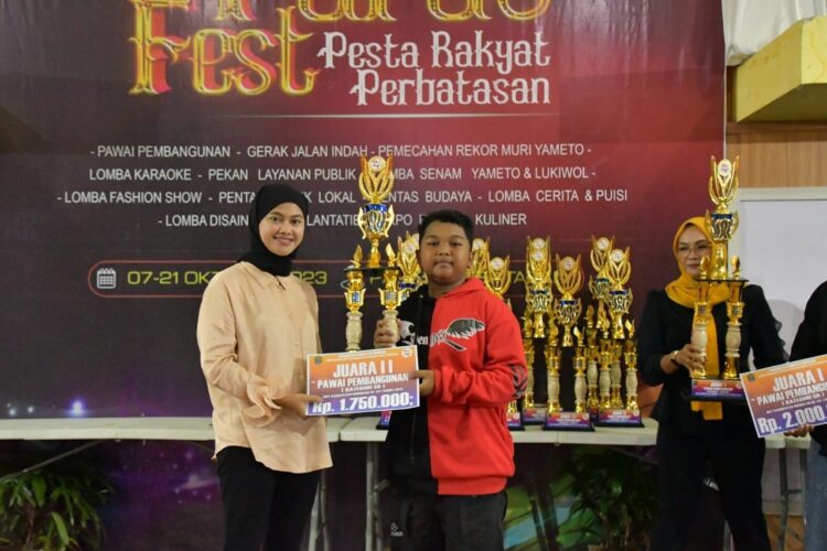 Bupati Nunukan Asmin Laura Hafid saat menyerahkan hadiah kepada salah satu pemenang lomba Pesta Rakyat Perbatasan (Paras Fest)