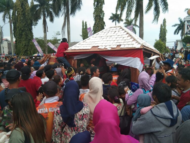 Penonton berlarian menuju Mobil Tempe untuk saling berebut tahu, tempe dan telur yang dibagikan secara gratis